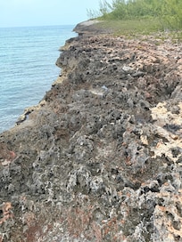 Rocky shoreline at the end of the road next to the dock.