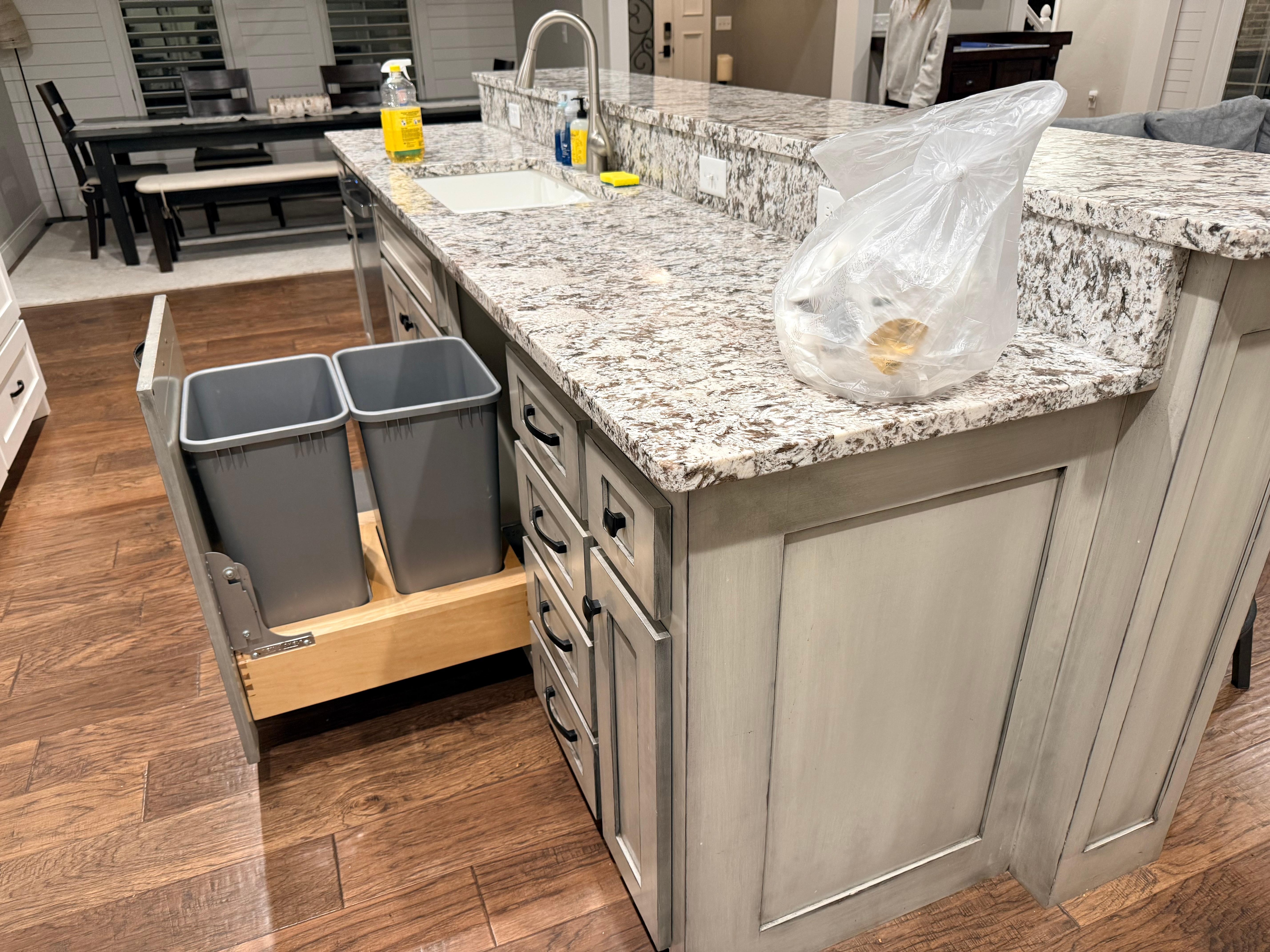 bag of trash and cleaning supplies left on kitchen counter