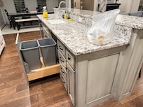 bag of trash and cleaning supplies left on kitchen counter