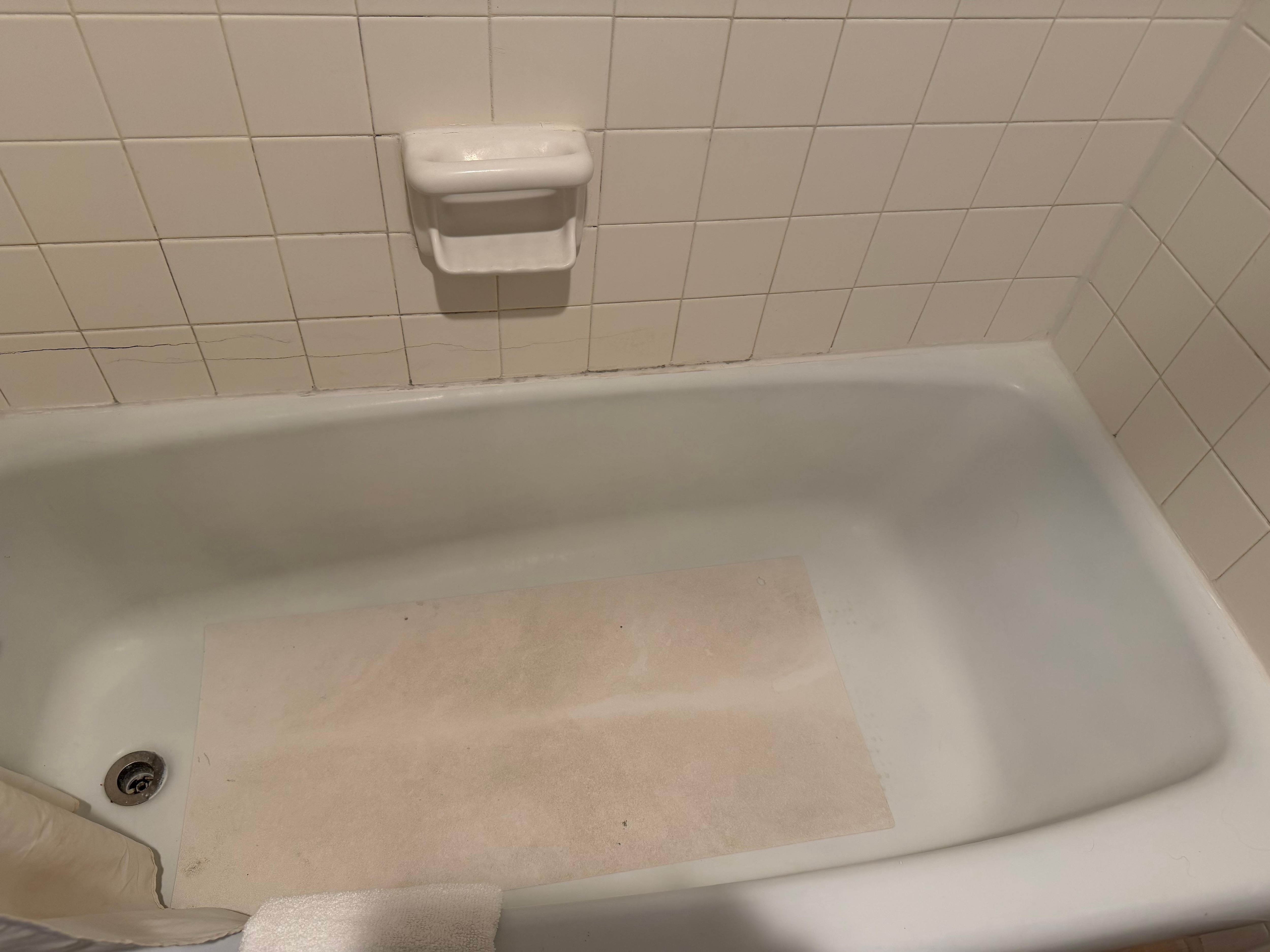 Dirty tub with discolored mat 
