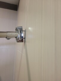 Shower curtain rod hanging on for dear life.