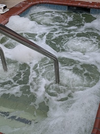 Brown , green , foamy hot tub water.