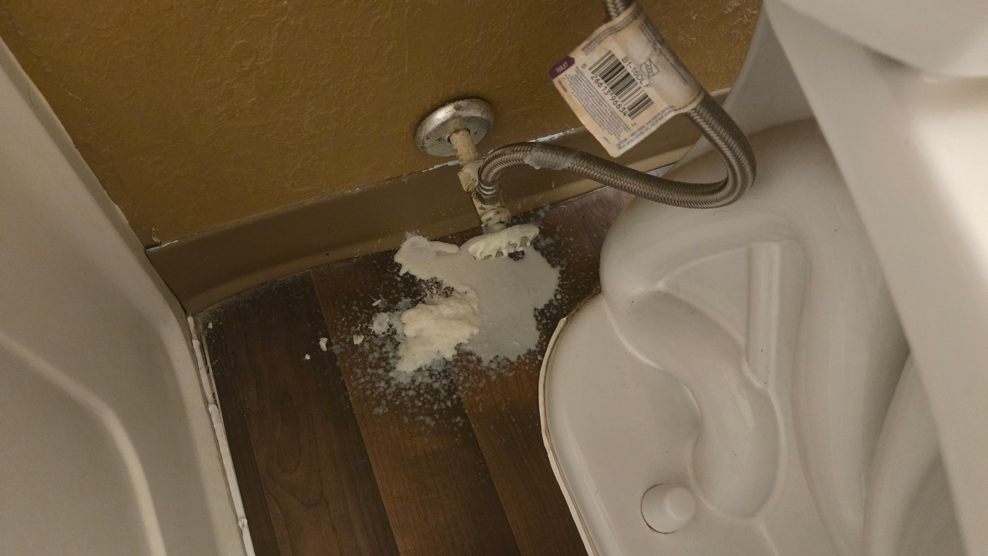 white substance pled up behind the toilet