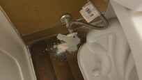 white substance pled up behind the toilet