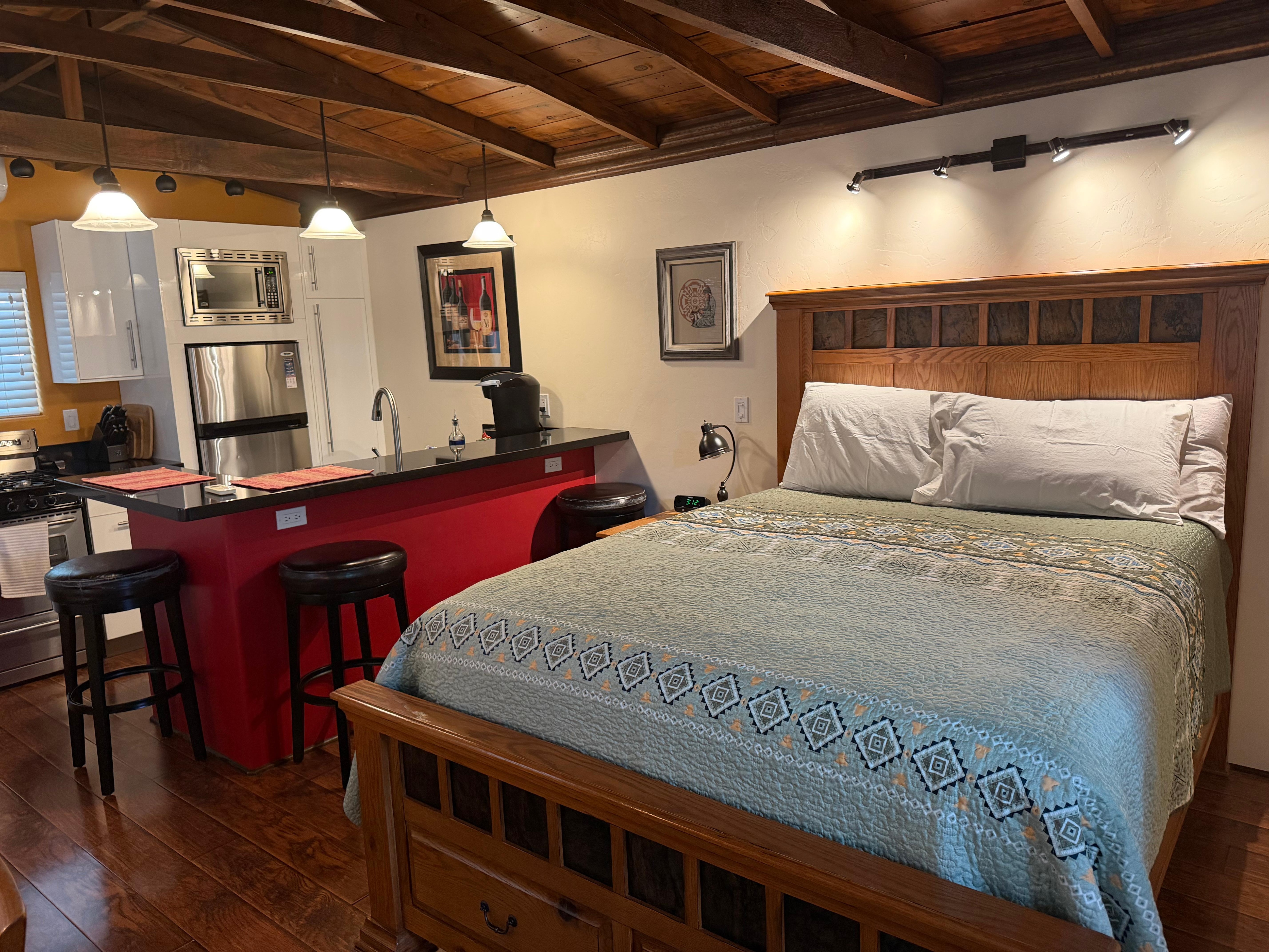 Main space with bed, TV, and kitchen. 