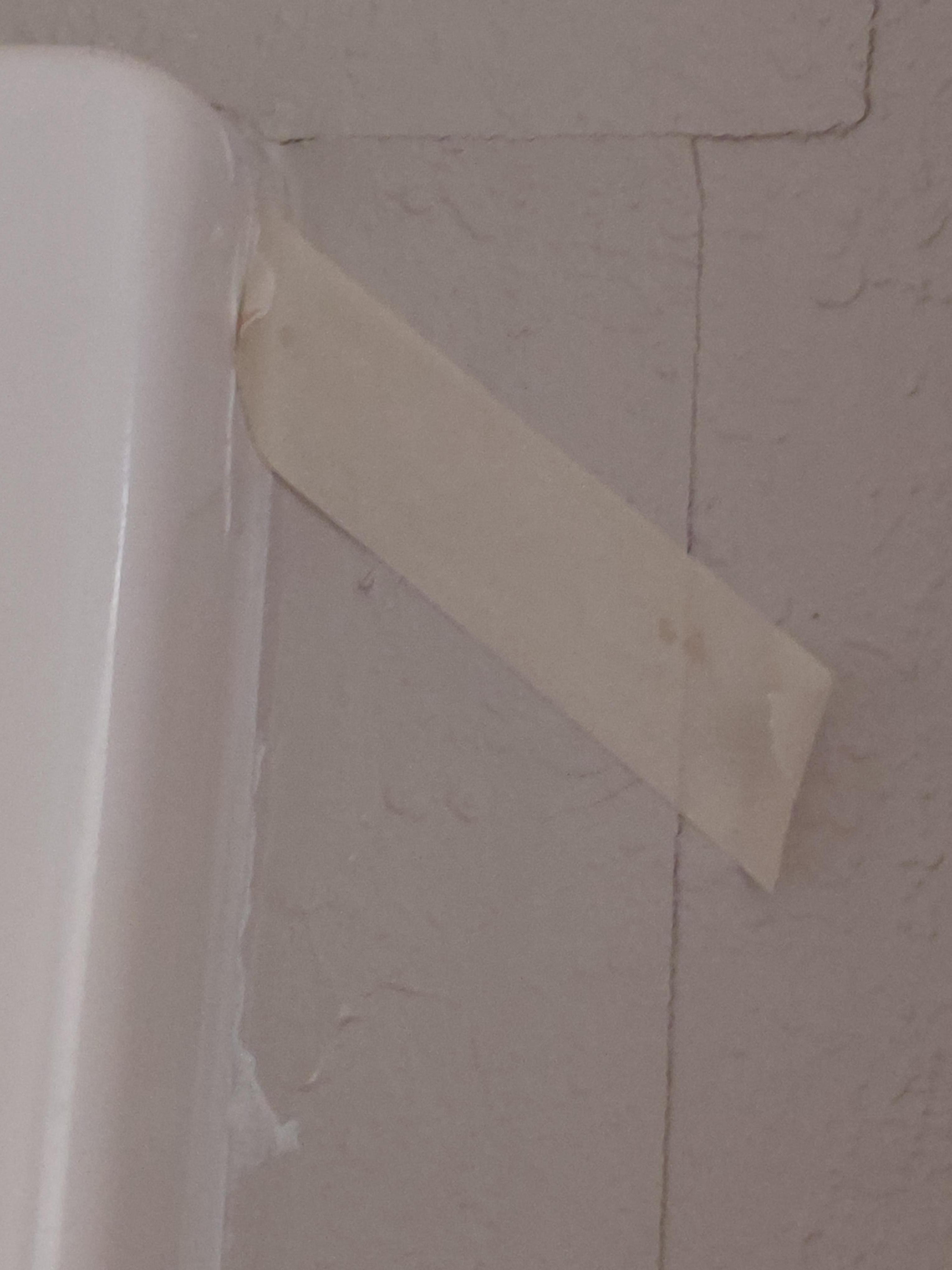 Wallpaper held on with masking tape