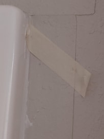 Wallpaper held on with masking tape