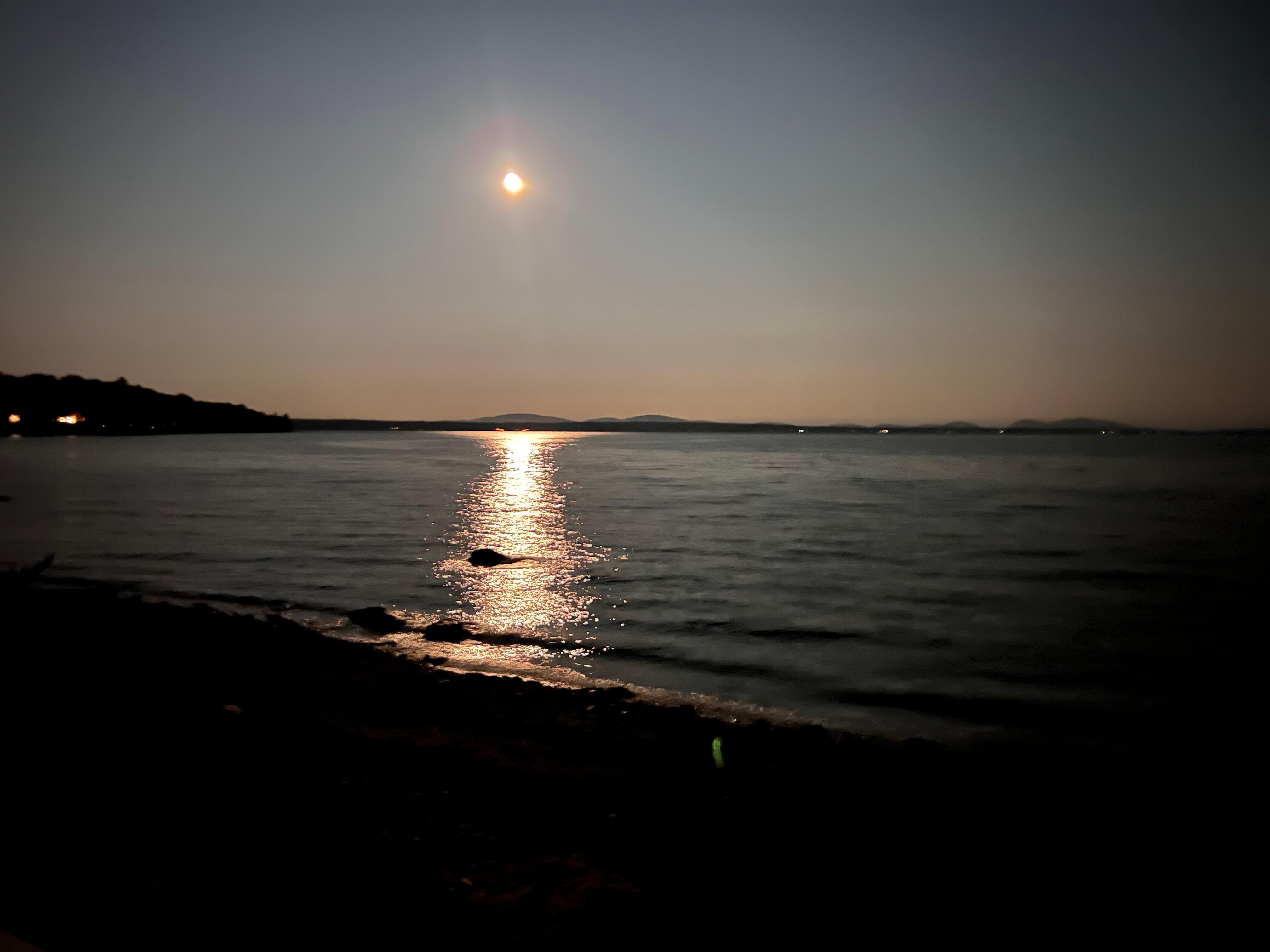 The moon shining over the water