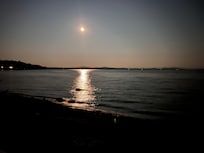 The moon shining over the water