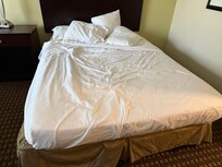 Aged mattress with flat, lumpy pillows.