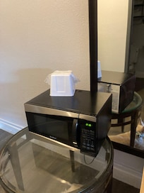 Microwave balanced on a glass table.