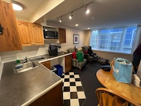 Small kitchen area with small tv. Able to open windows but have locks to secure.