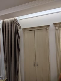 loshangend gordijn voor een raam{pje) met uitzicht op een trapgat