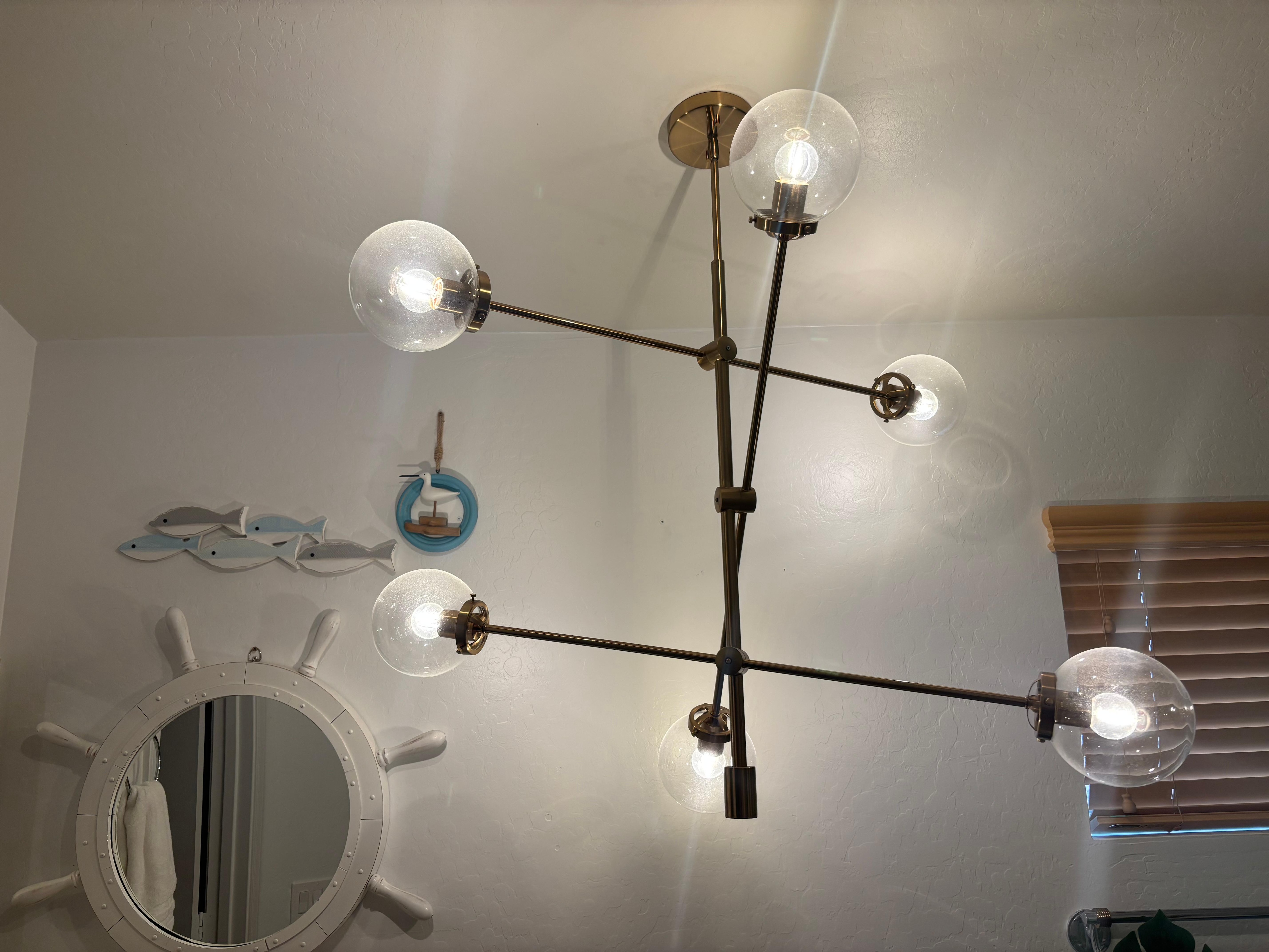 Light fixture in the primary  bathroom. Needs to be cleaned too and hangs a little low for taller people. 