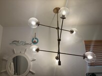 Light fixture in the primary bathroom. Needs to be cleaned too and hangs a little low for taller people.