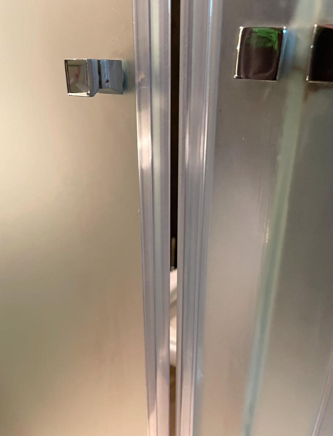 Glass partition for toilet not fully closing, offering no privacy
