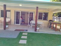 A low set house with a spacious veranda and a lovely grassed front lawn with gardens and solar lighting .