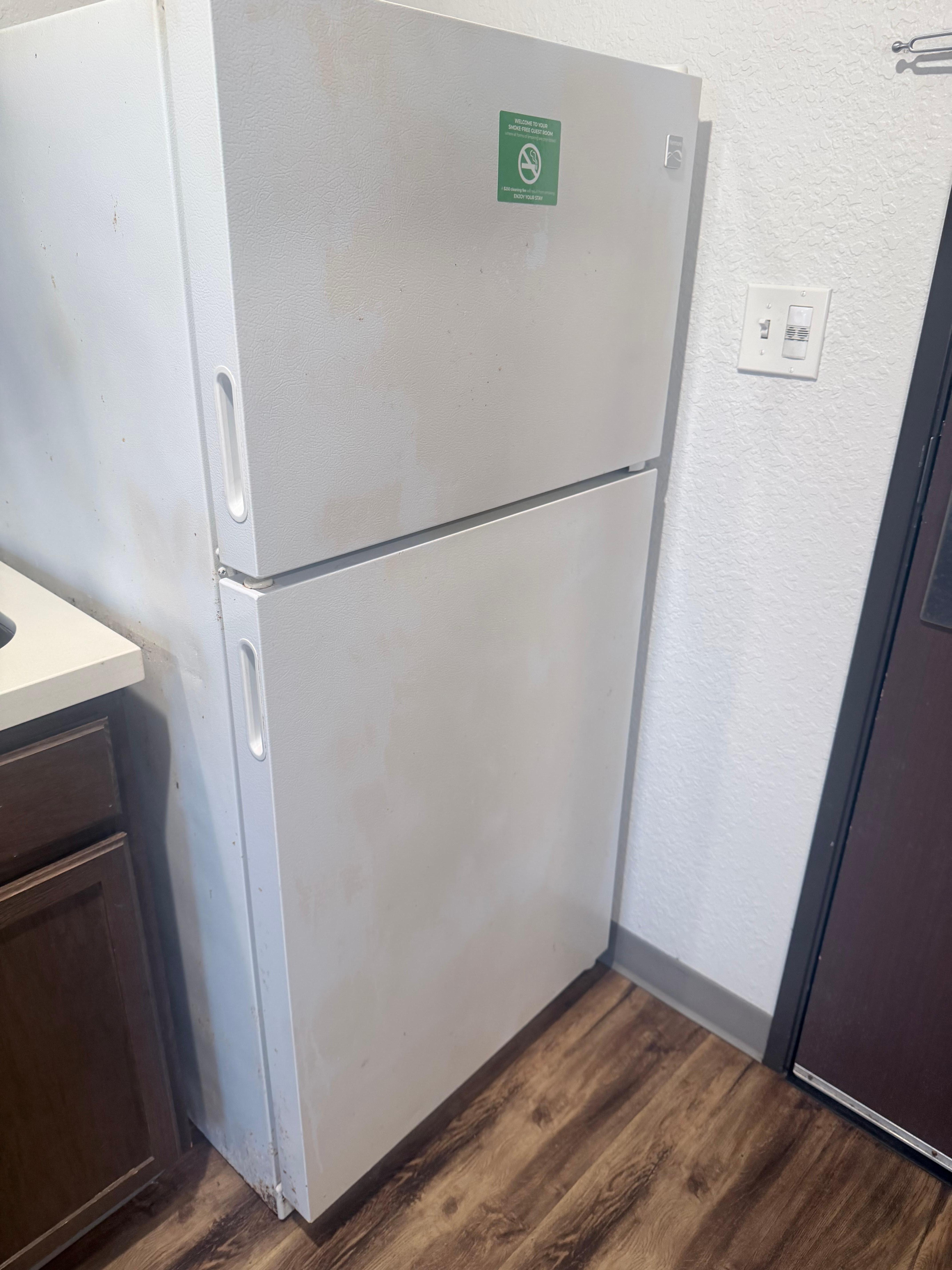 Front and side of rusted fridge
