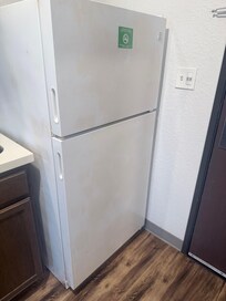 Front and side of rusted fridge
