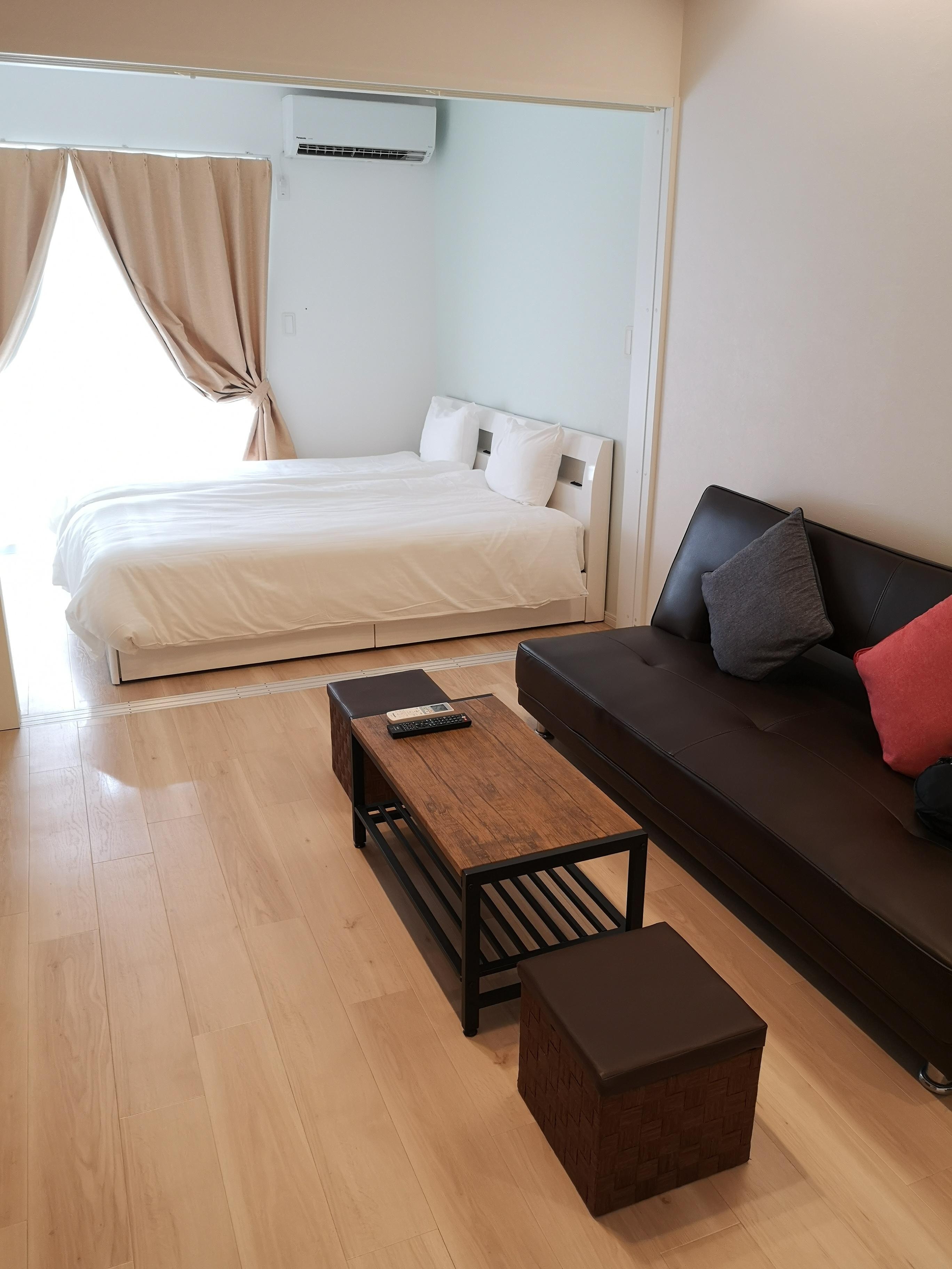 ベッド２つ並んでいます。ベッドルームとリビングルームは引き戸で２部屋になります。ソファーの前にテレビあります。