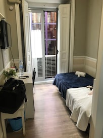 Chambre toute en longueur, étroite mais optimisée avec lit une place sur le côté. Pas d’interrupteur lumière depuis le lit ni de lampe d’appoint (seul plafonnier). Pas de rangement dédié hormis une tringle (donc séjour de courte durée nécessairement)