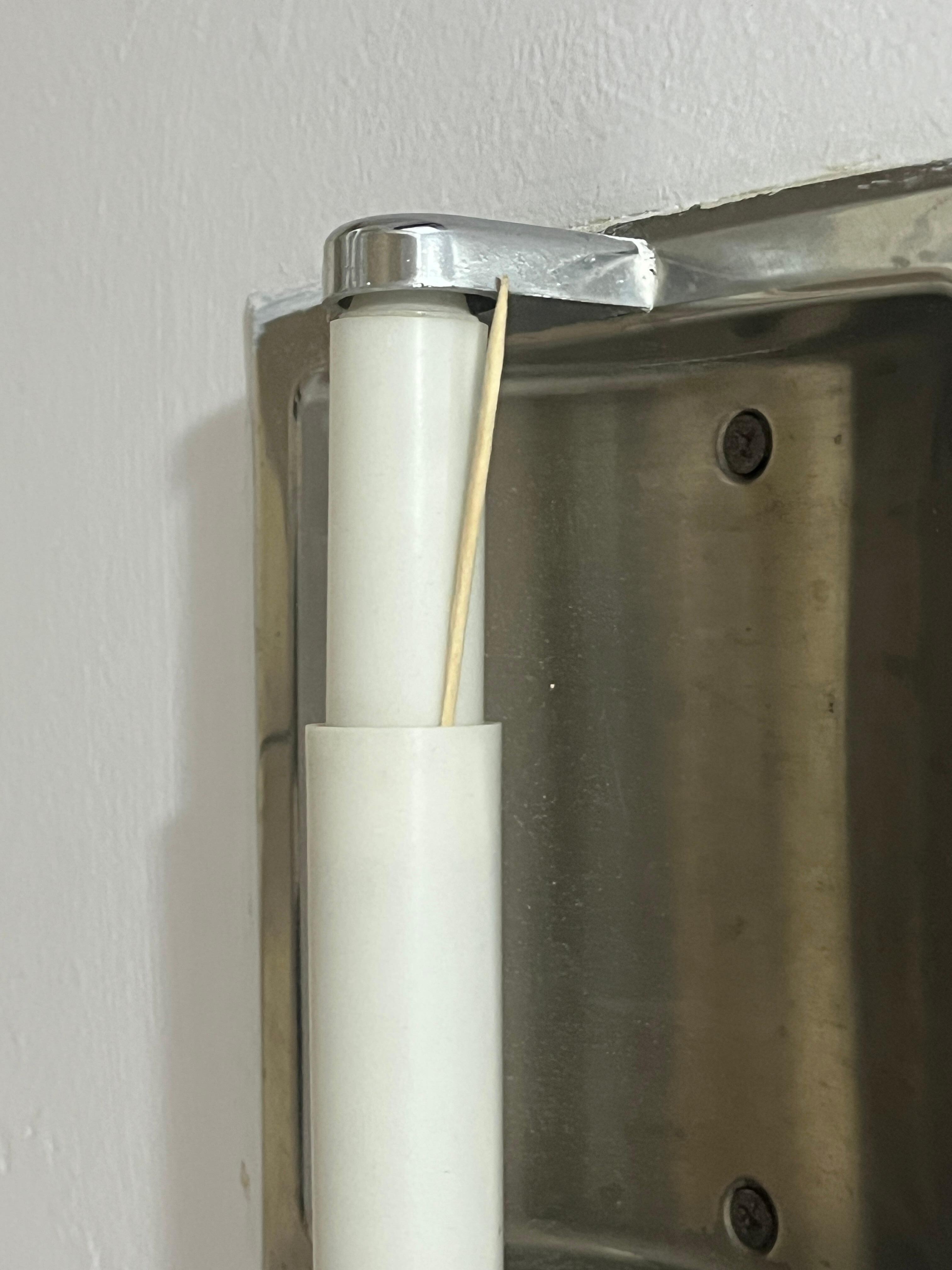 Toothpick laying on the toilet paper holder