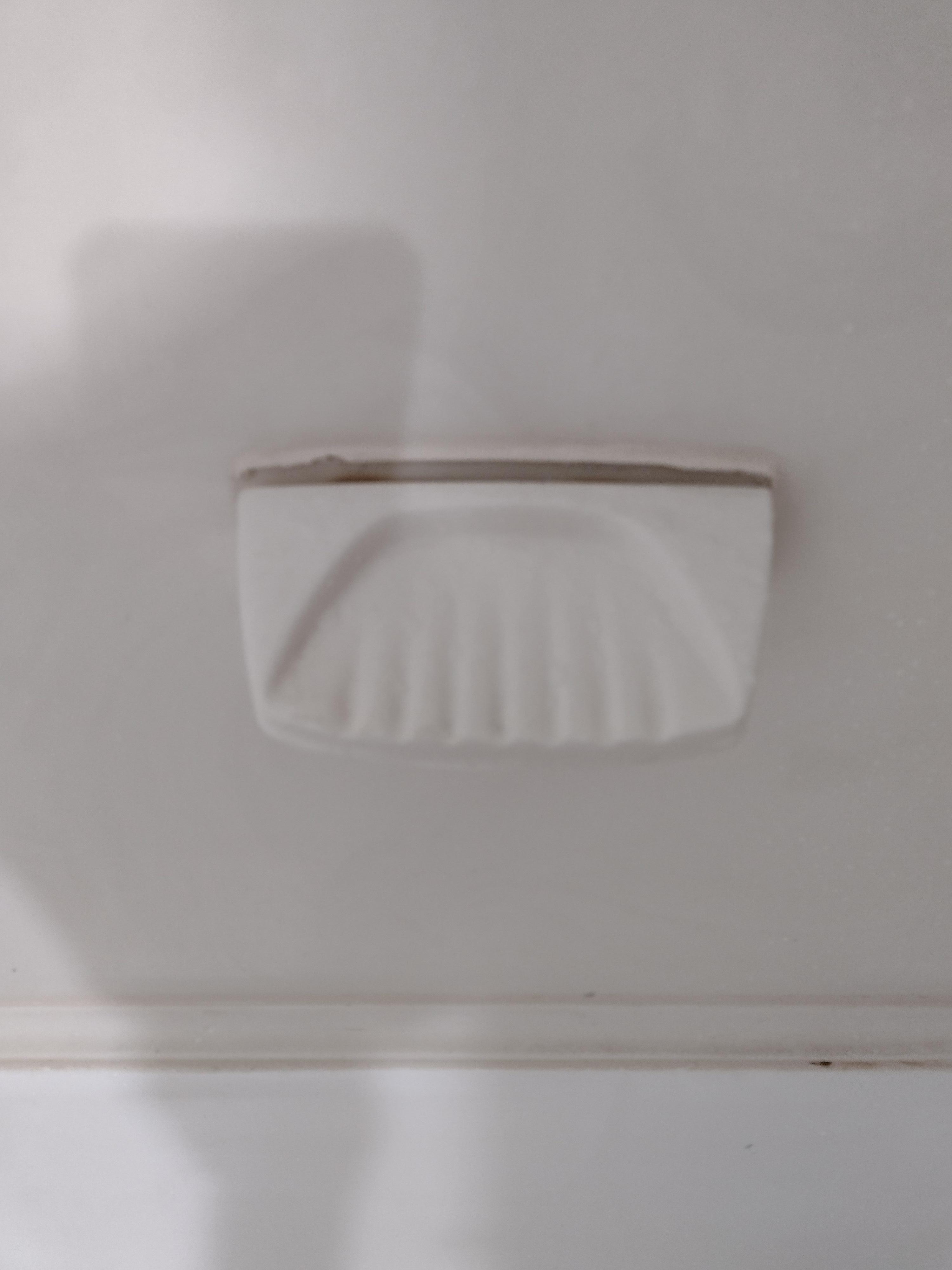 Soap holder in shower peeling off wall.