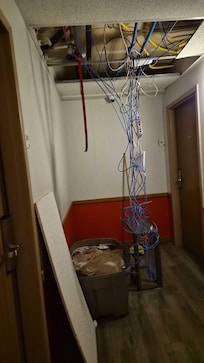 Tub was full of water from a leak, which was also leaking into the lobby a floor below. Ethernet wires hanging down.