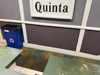 Registration desk worn down, broken edges. Wall has loose panels.