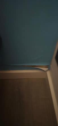 Ripped wallpaper near the bed