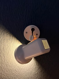 Bedside lamp hanging out of the wall above the bed