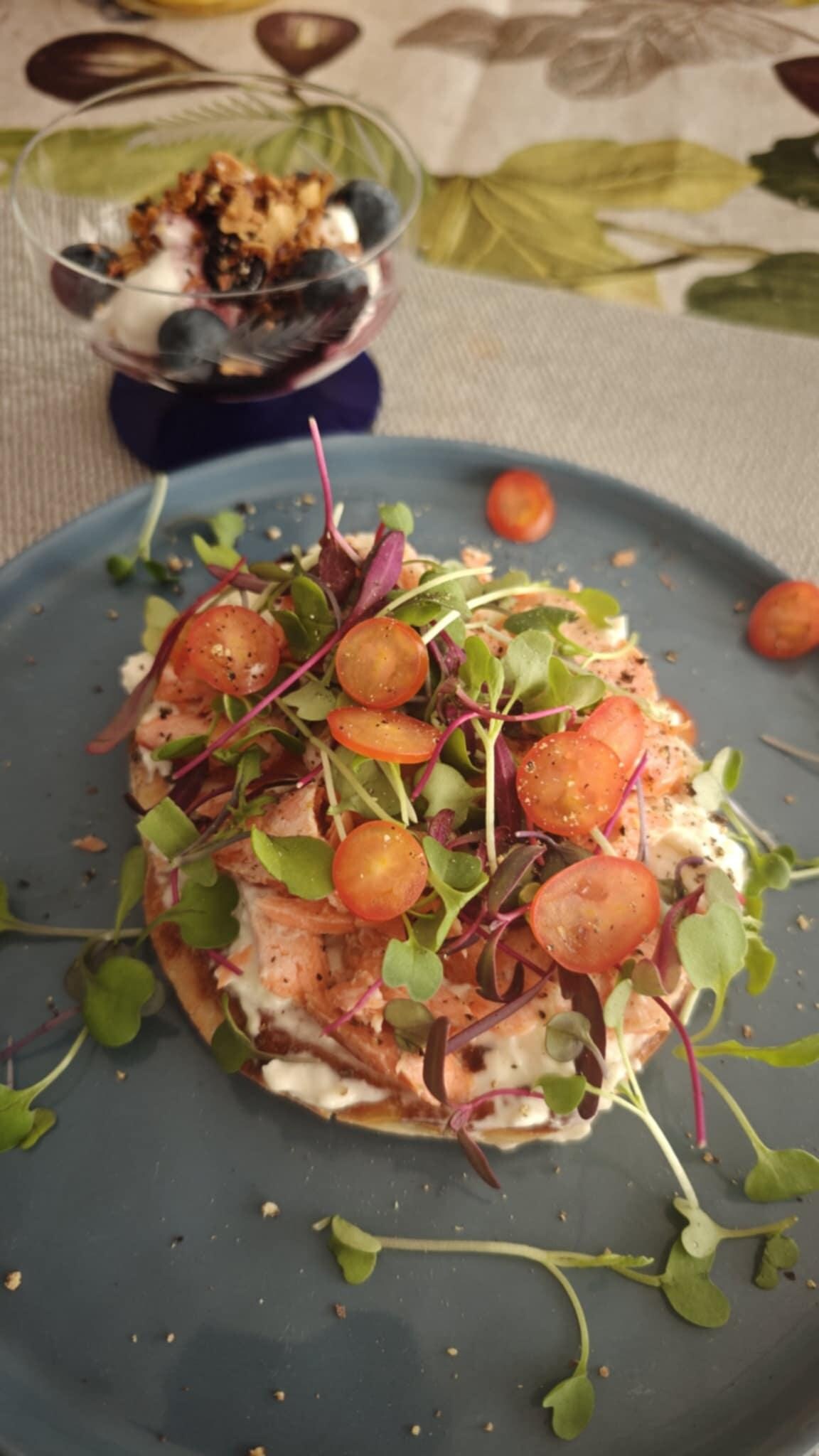 Home smoked Salmon on cream cheese, tomatoes, micro greens on bagel. 
