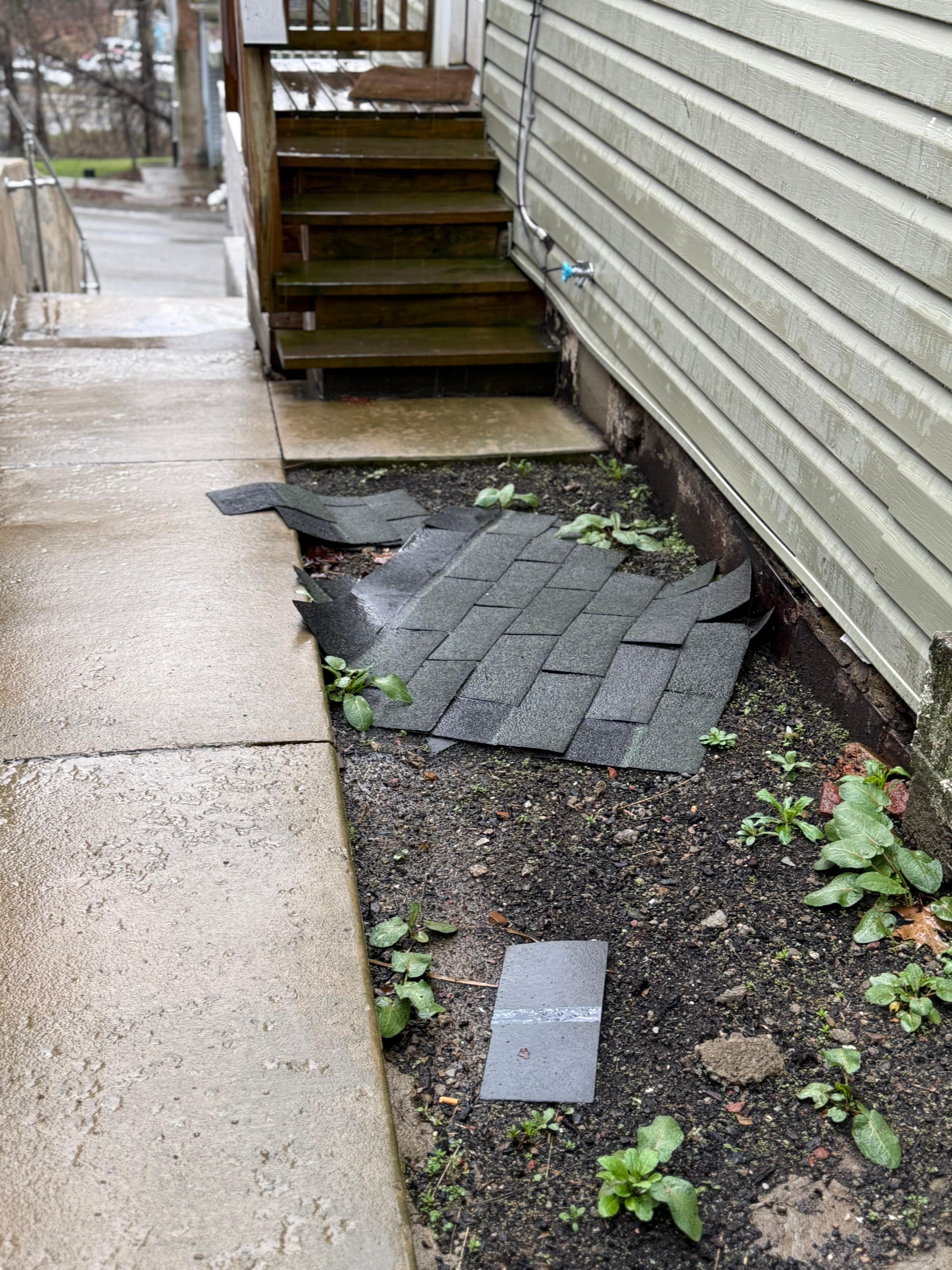 Roofing on sidewalk to entry.