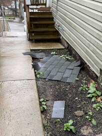 Roofing on sidewalk to entry.