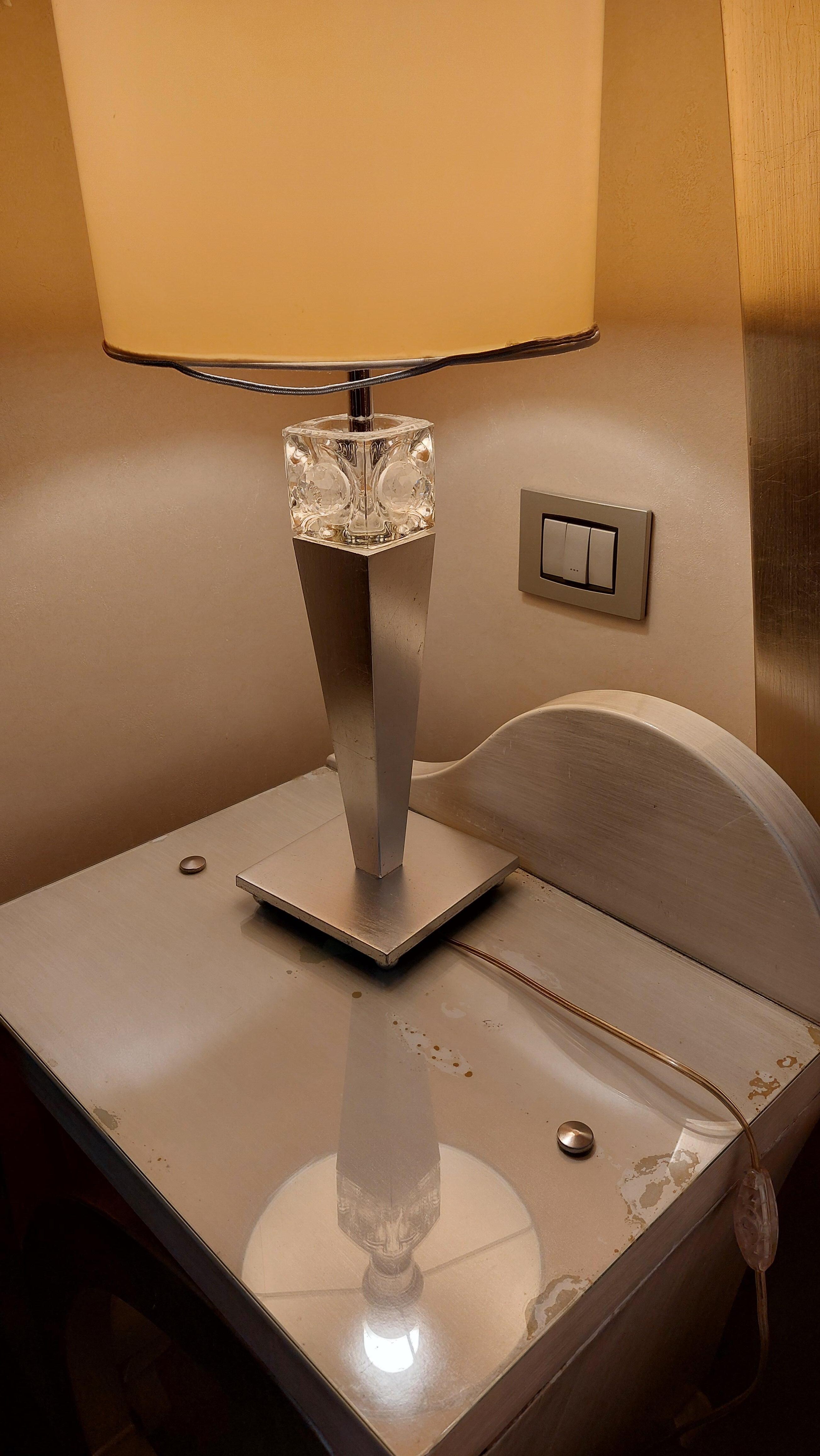 Vies nachtkastje met half kapotte lamp