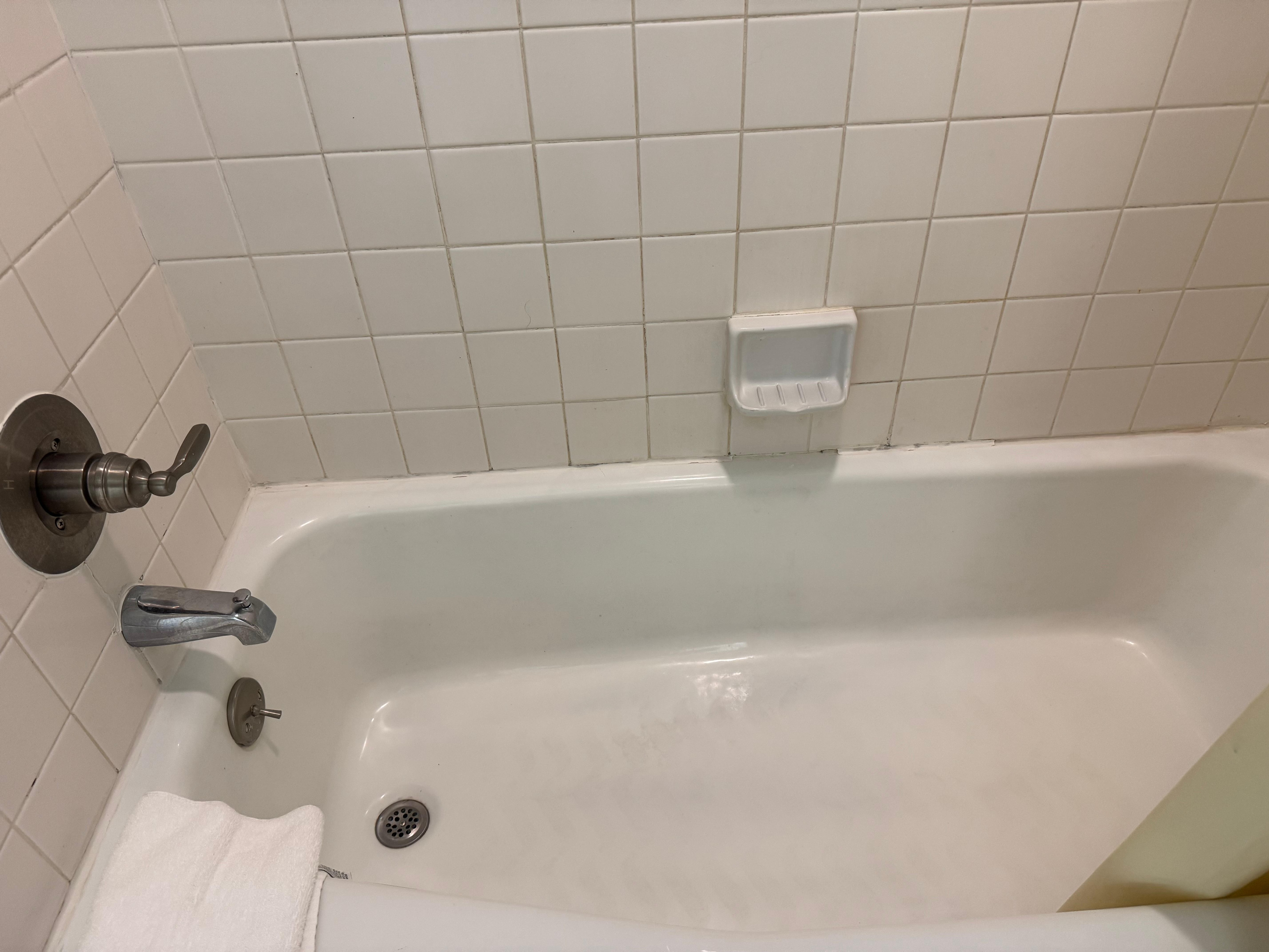 Dirty grout and ancient tub. 