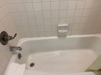 Dirty grout and ancient tub.