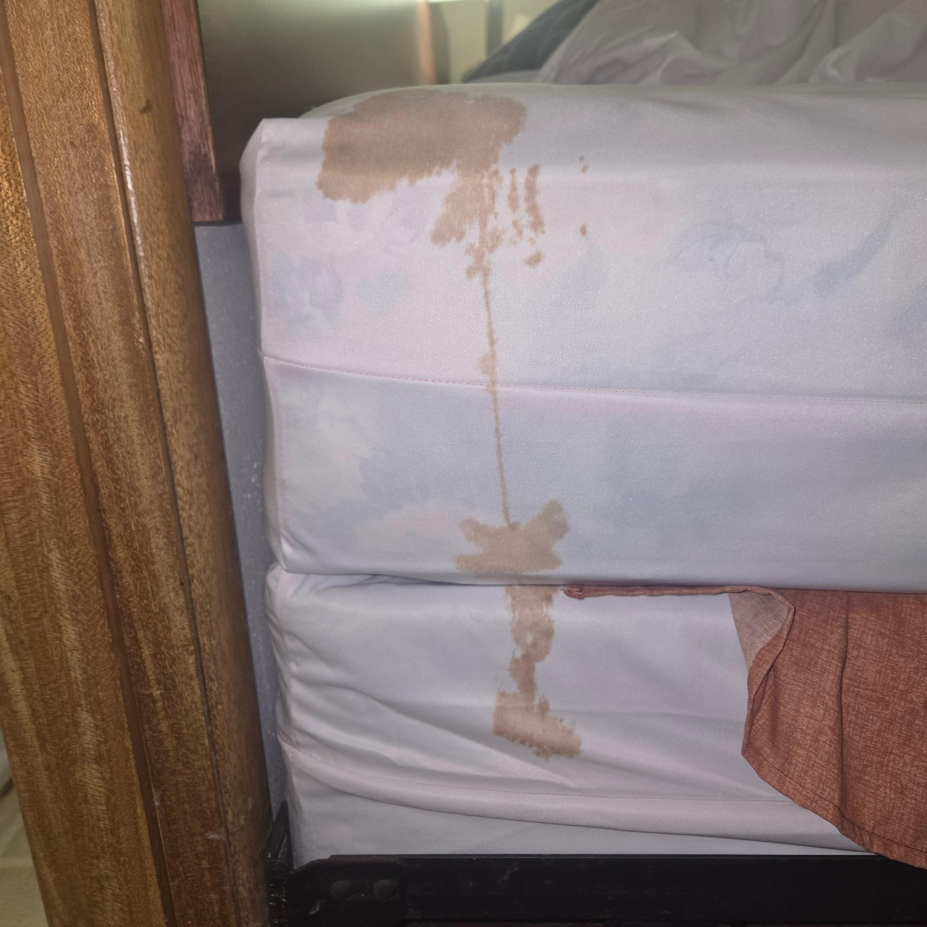 This is the bed skirt pulled back revealing the spilt mark going all the way down. If the sheets were washed or just stained both sheets more then likely wouldnt have ended up back in the same exact spot on same exact bed. DISGUSTING!!!!