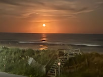 Watched red moon rise over ocean from deck.