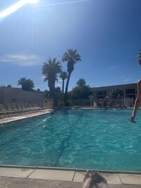 Clubhouse pool looking toward the building with this condo. The balcony has a large tree in front of it that makes it feel more private.