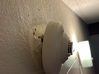 Smoke detector hanging by wires