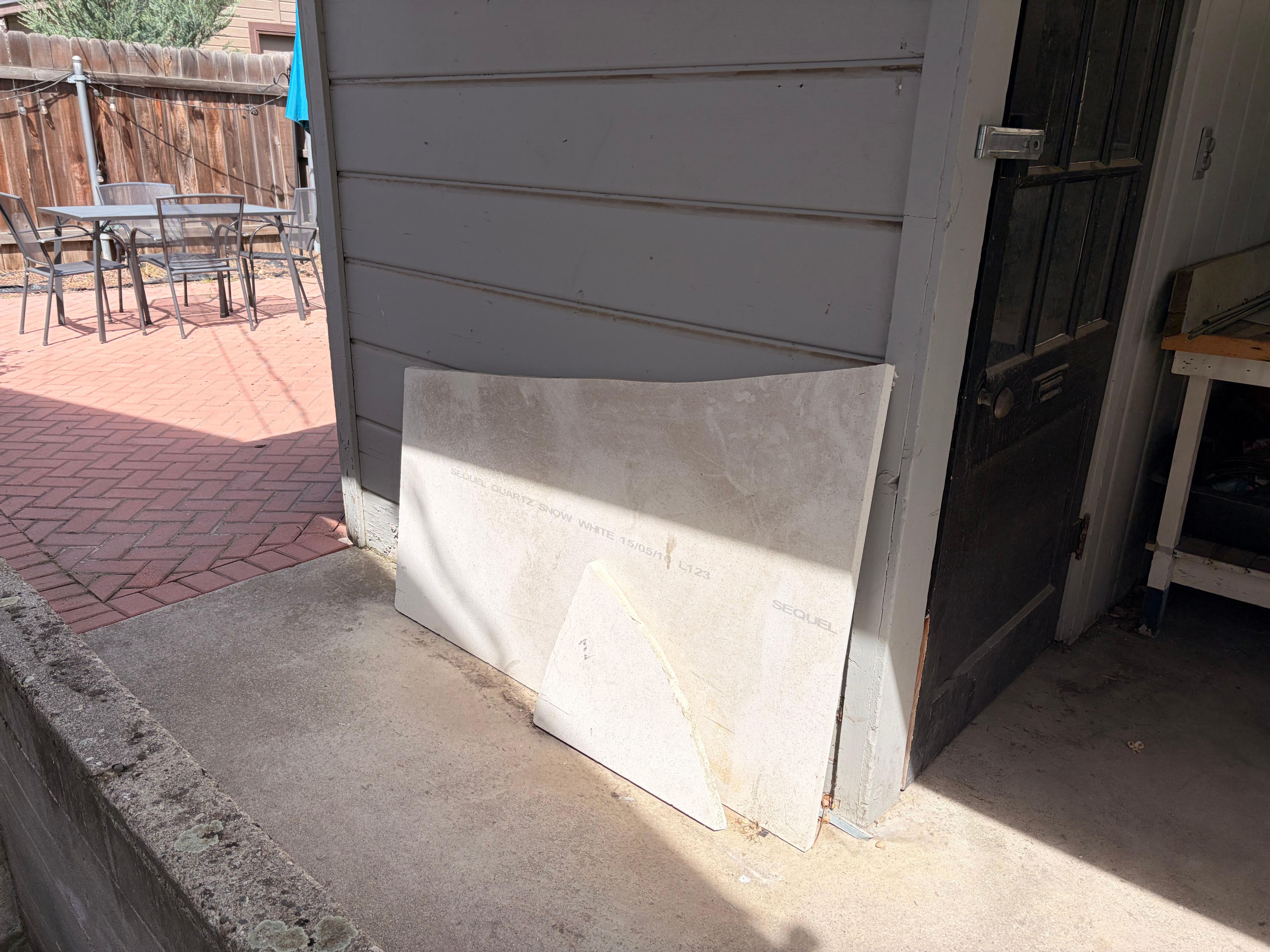 Pathway from front door to patio seating area had this broken piece of granite Precariously leaned up against the wall