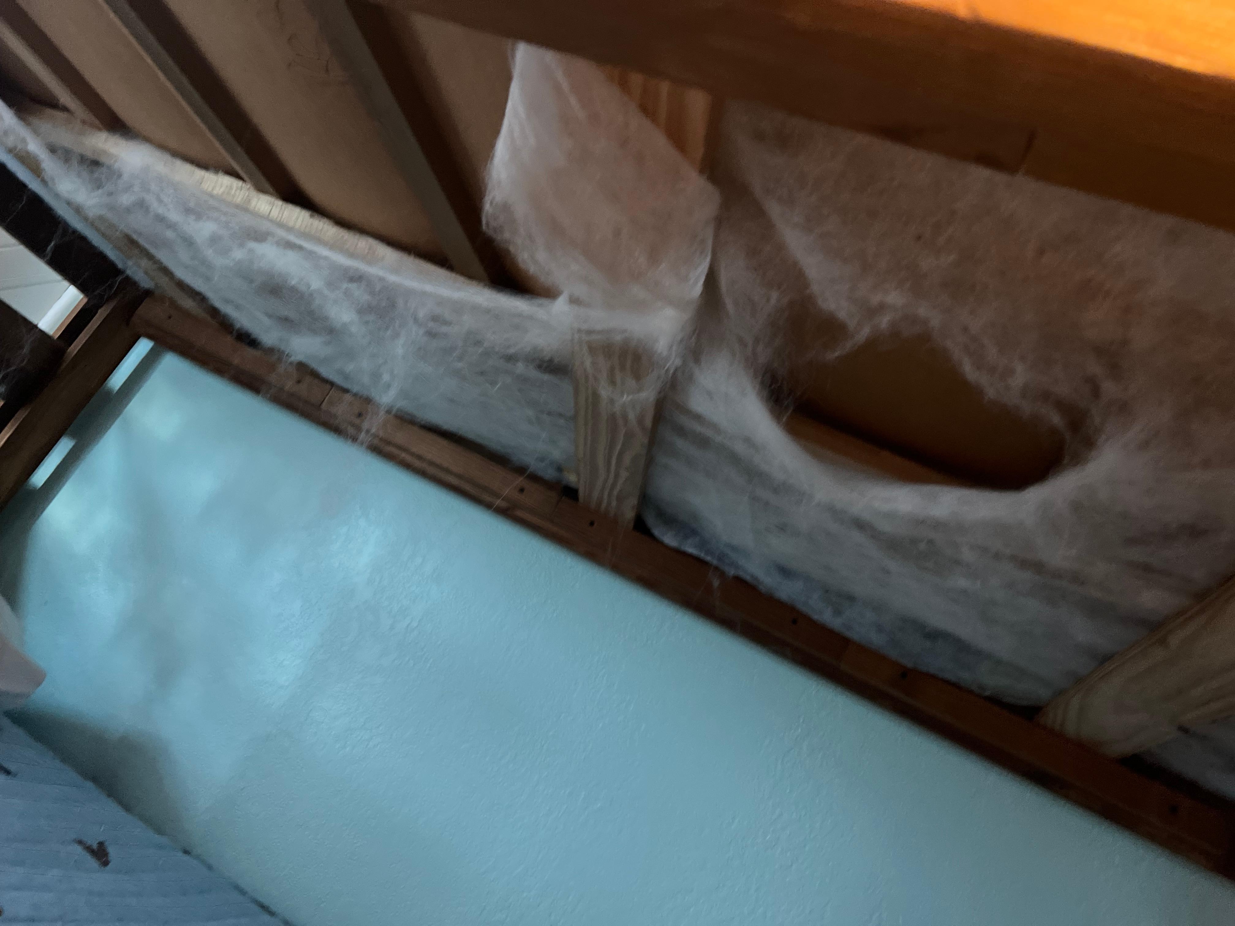 Bunk bed on right side of room with webbing hanging down. 