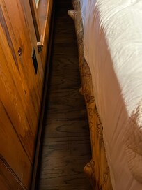 Narrow space between the bed and the wall with knots on the bed frame you may have to watch out for!