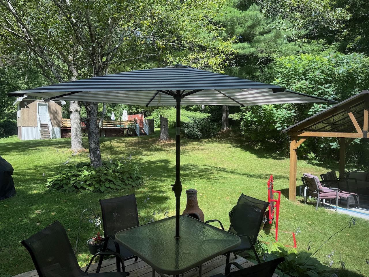 Backyard with pool in back. Nice deck in front and covered seating area with fire pit to side