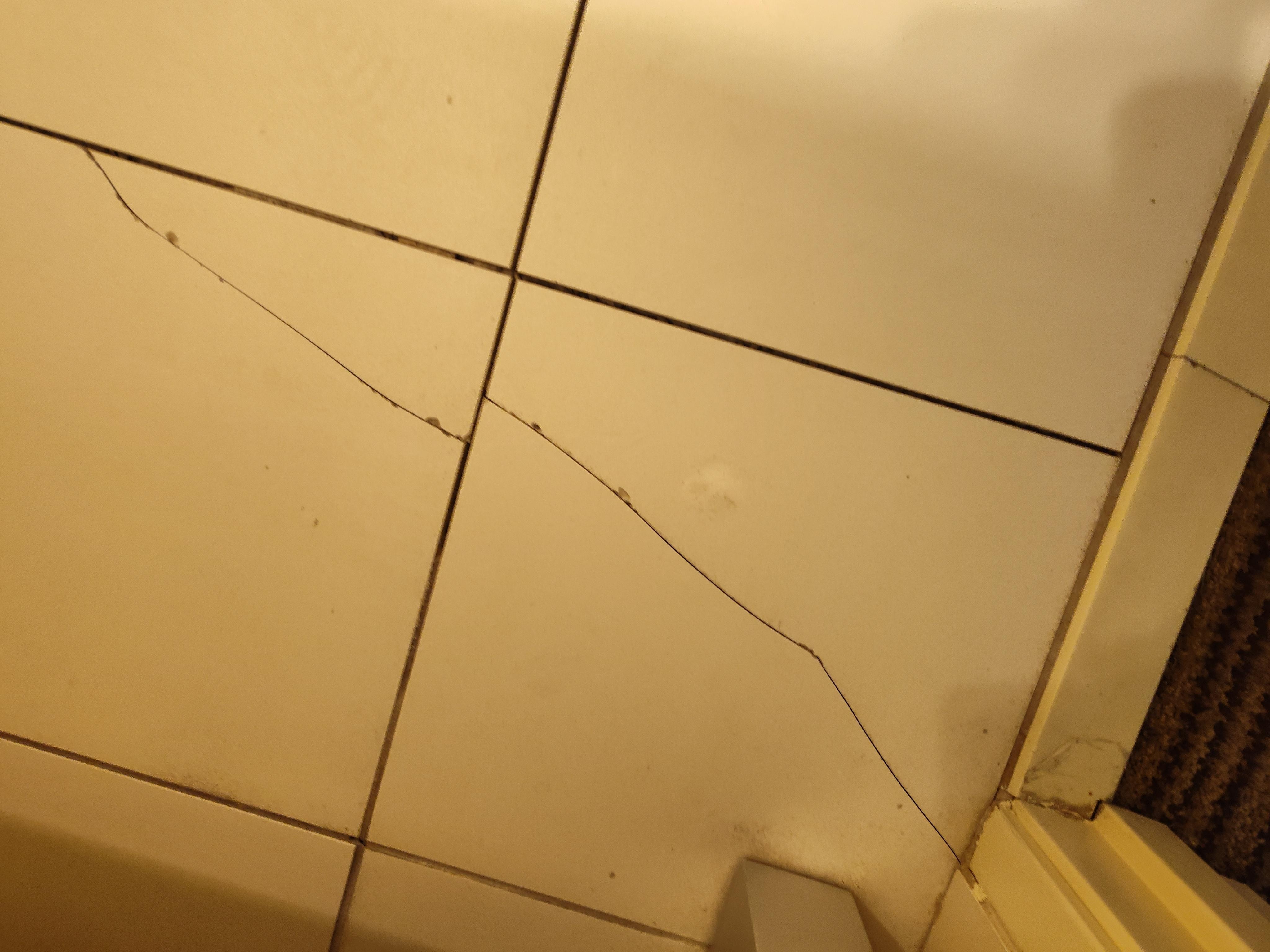 Cracks in more bathroom tile and not stuck down