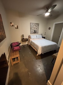 Spacious bedroom that also has a giant TV on the wall.