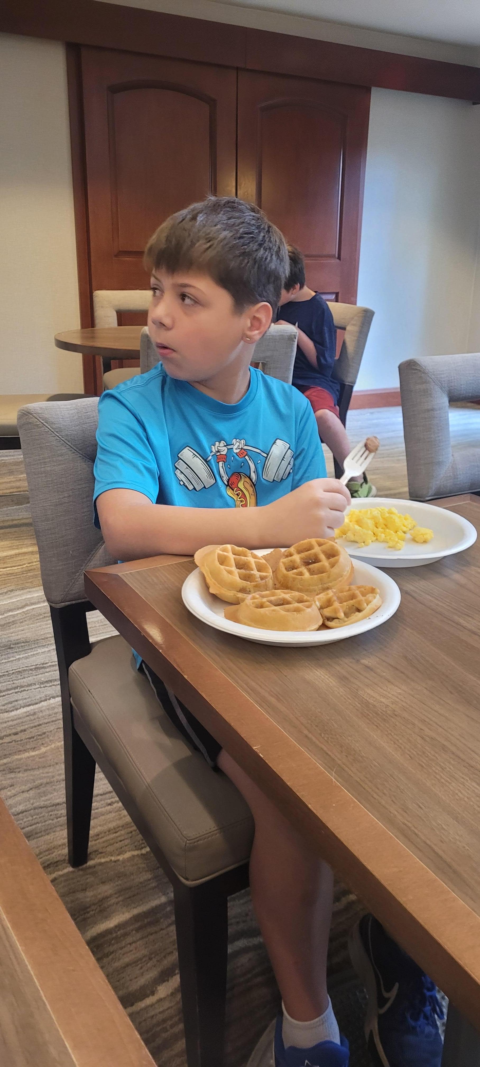 Good morning breakfast with sausage, eggs, bread, yogurt, waffles, beverages, cereals
