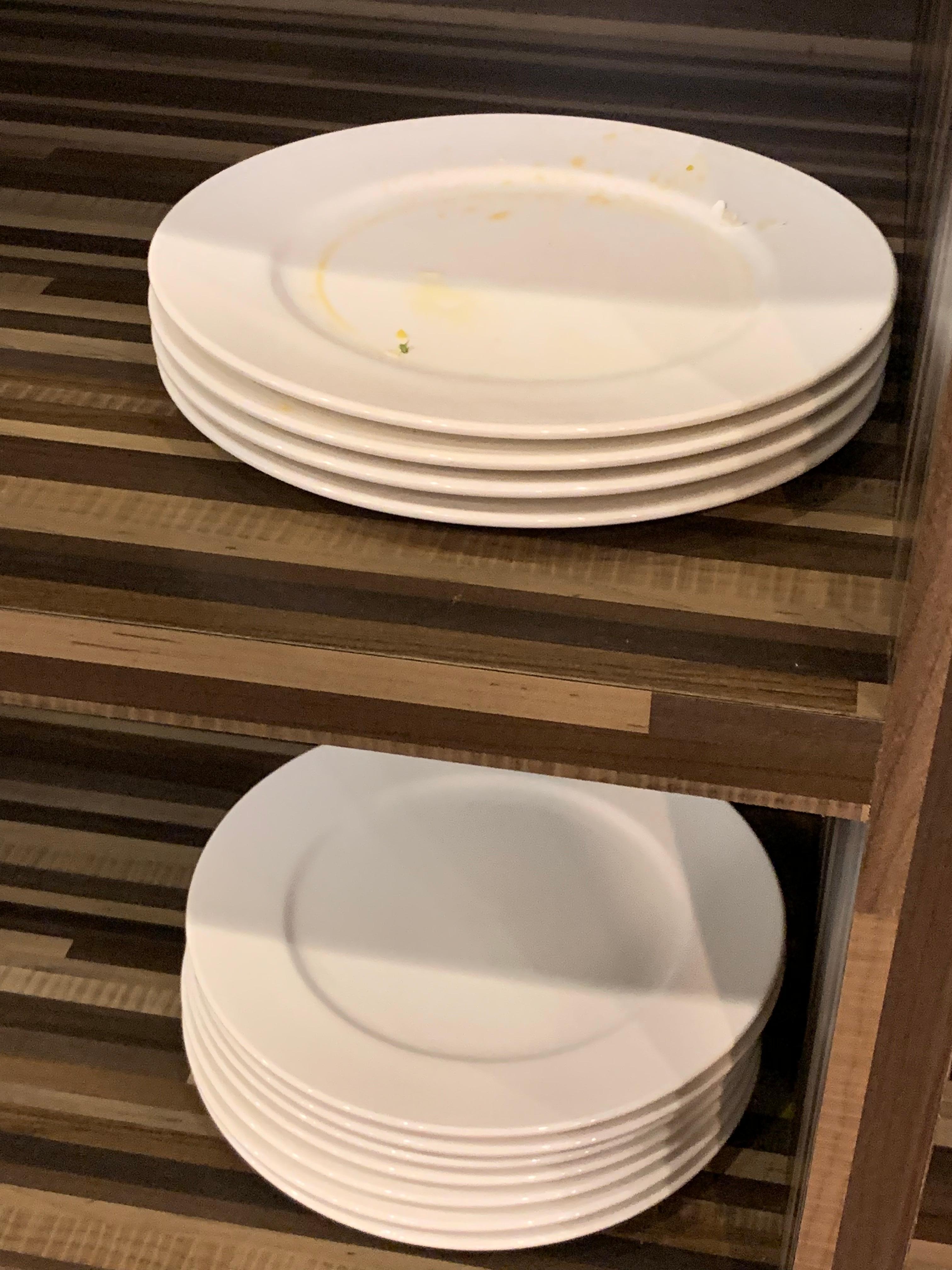 Dirty and clean plates all stacked together 