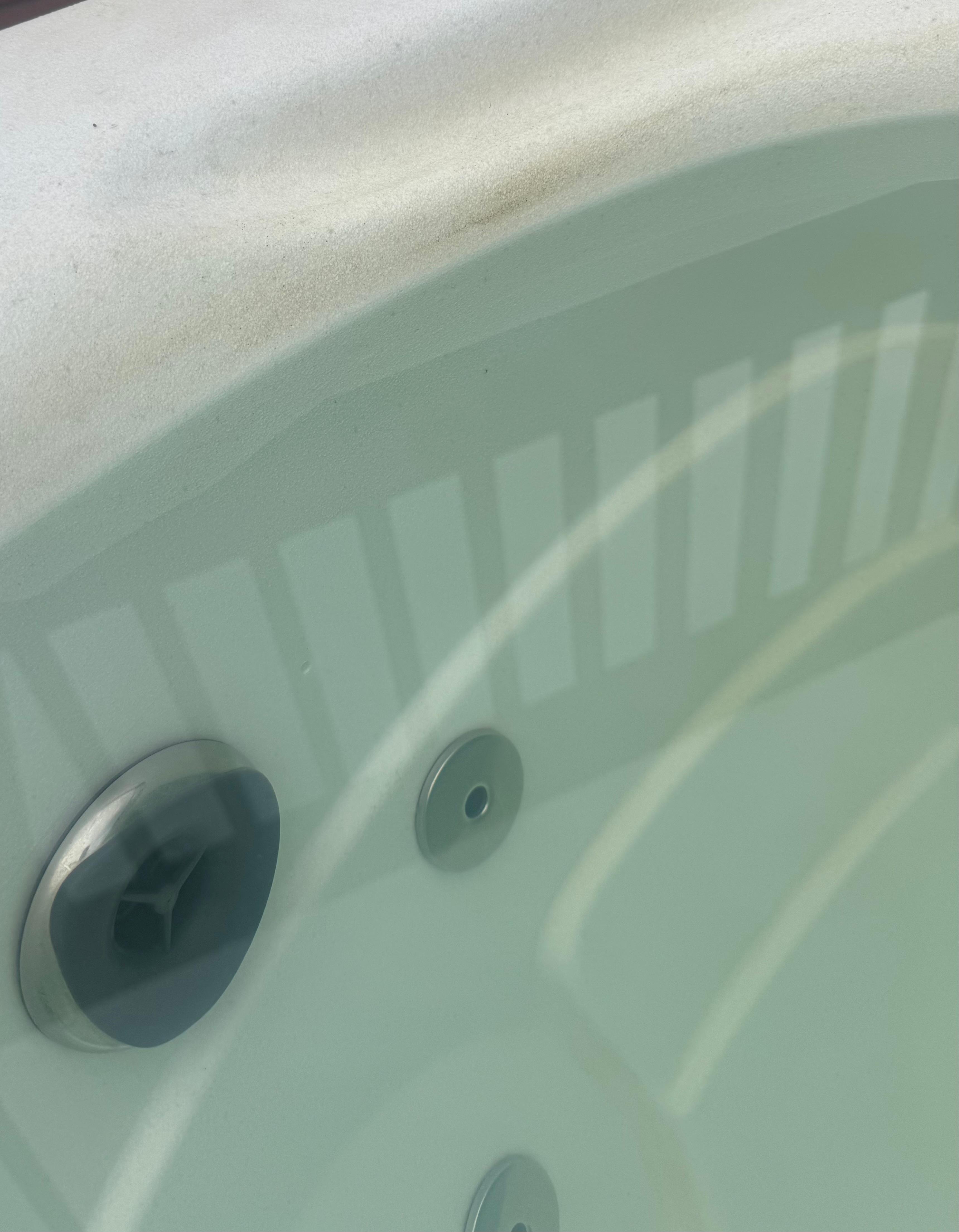 Dirty hot tub side and green water.